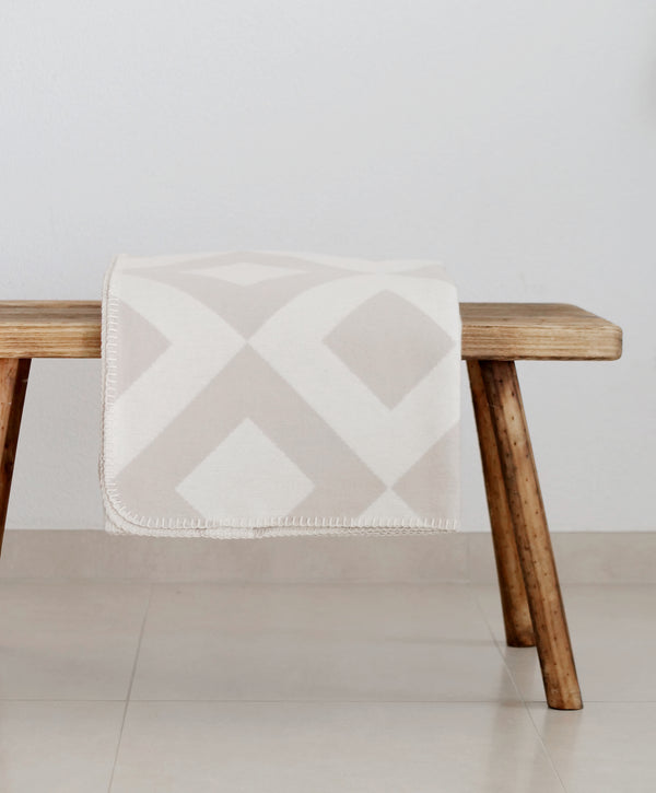 RIEMA Kuscheldecke LASSE aus 100% Bio-Baumwolle beige natur dekoriert auf Holzbank