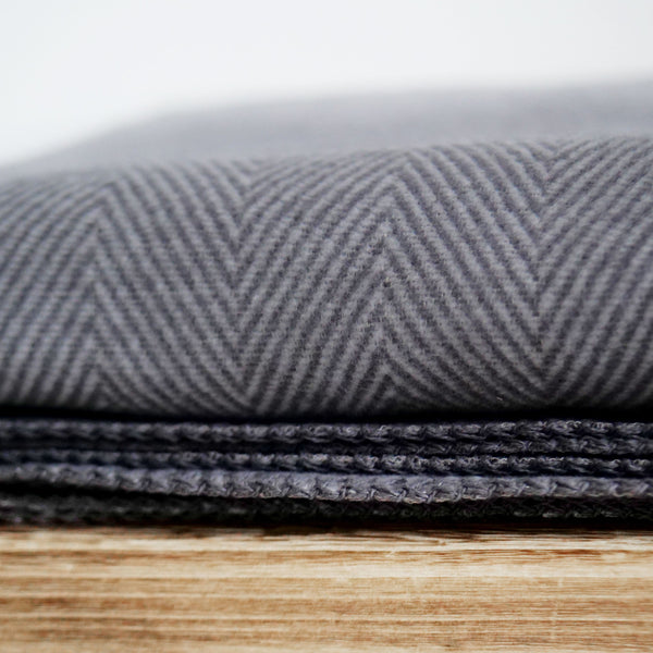 RIEMA weiche Kuscheldecke dunkelgrau auf Holzbank