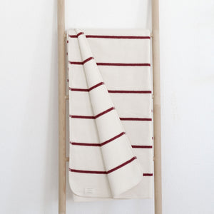 RIEMA Kuscheldecke Jule aus 100% Bio-Baumwolle auf Holzleiter in rot