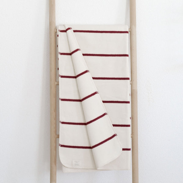 RIEMA Kuscheldecke Jule aus 100% Bio-Baumwolle auf Holzleiter in rot