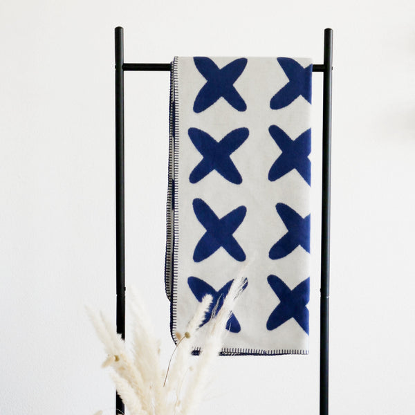 riema Bio-Baumwolldecke KJELL mit Kreuzen in blau über Kleiderständer, Made in Germany