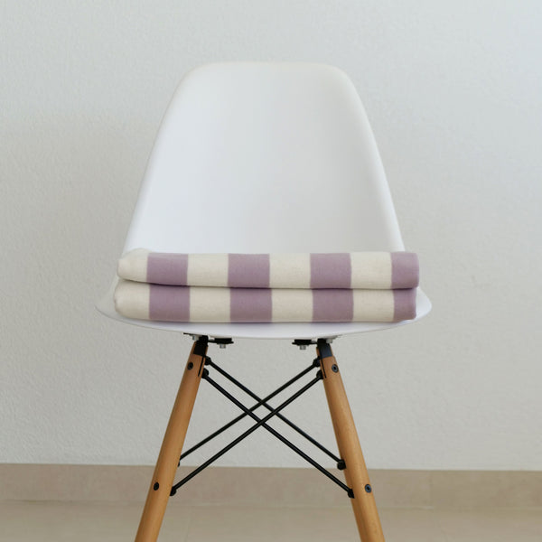 RIEMA Kuscheldecke aus 100% Bio-Baumwolle, weich und kratzfrei, auf einen Stuhl gelegt