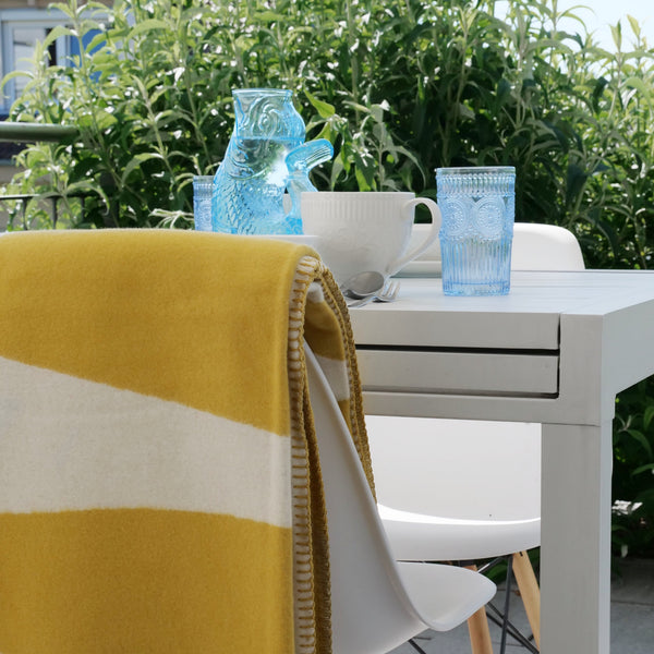 RIEMA sommerliche Kuscheldecke AURORA auf Terrasse im Garten mit Sonne