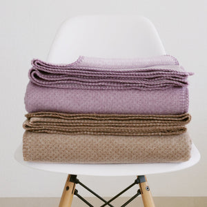 riema Kuscheldecke EMMA aus Bio-Baumwolle kba in der Farbe braun und Malve auf Stuhl
