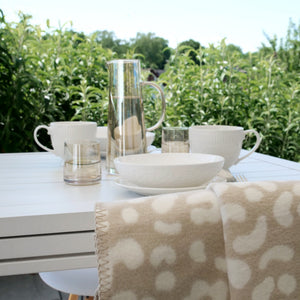 RIEMA XL Decke LIA in beige mit Leomotiv auf Terrasse/Balkon im Sommer