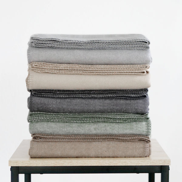 RIEMA XL Kuscheldecke BJÖRK recycelte Baumwolle, 150x230 cm in braun, grau, dunkelgrau, grün, beige, gefaltet und gestapelt